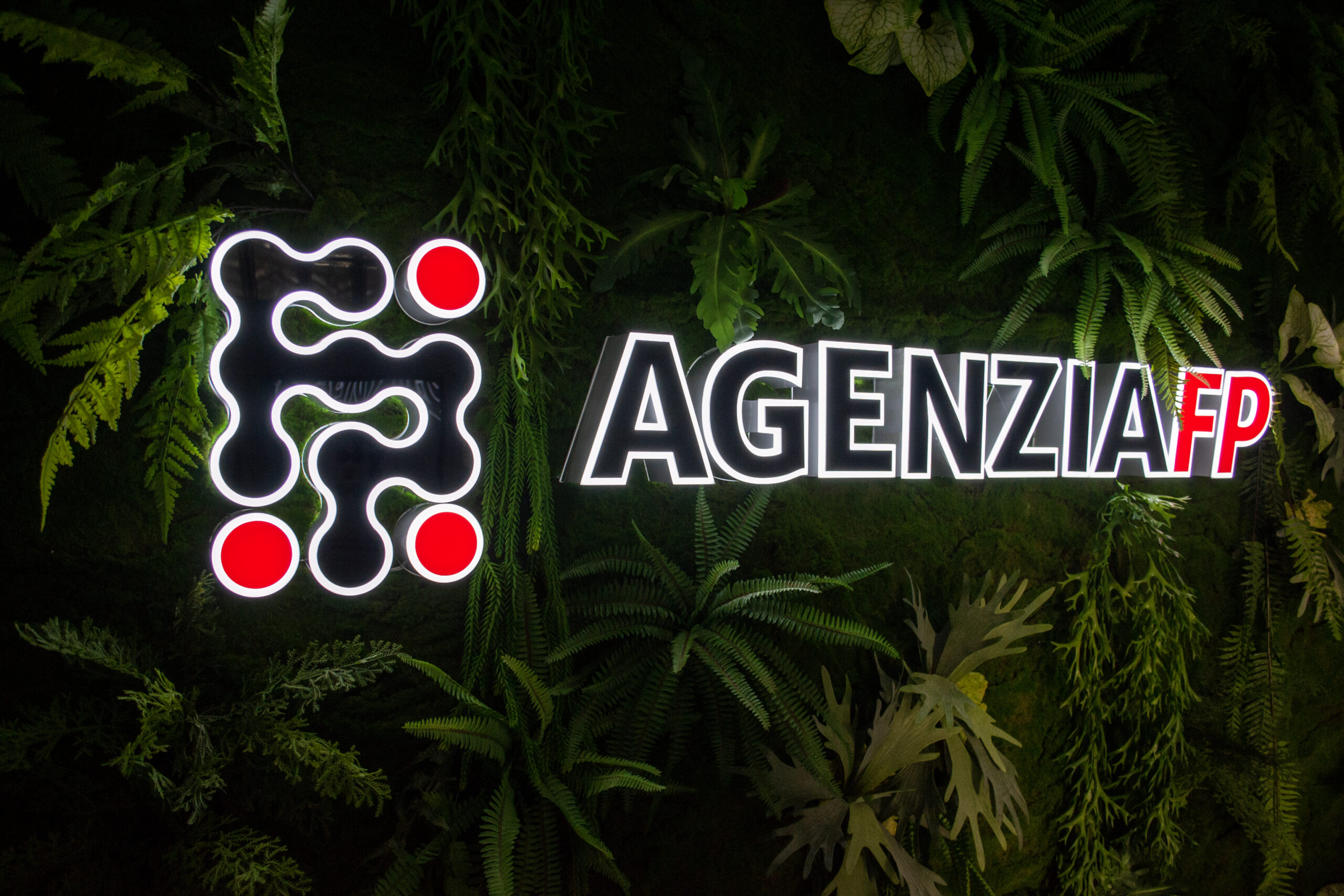 Il logo AgenziaFP sulla parete verde dell'ufficio